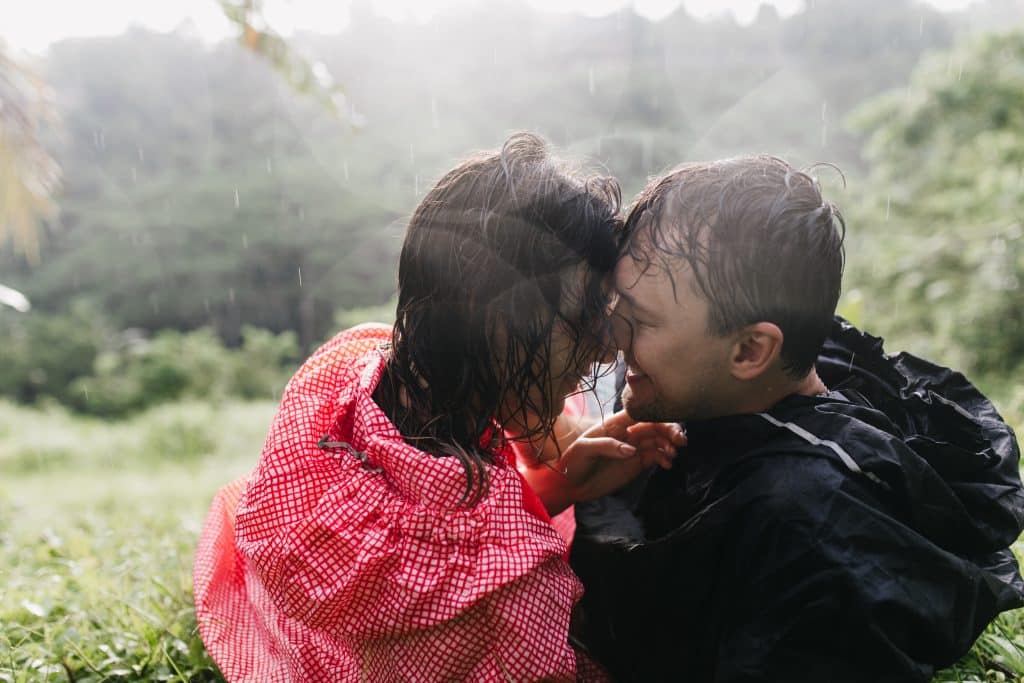 Enchanting girl with wet hair lying on the grass after travel with boyfriend. Outdoor shot of woman