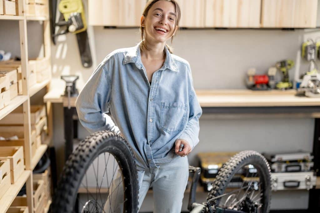 Handywoman reparing bicycle in the workshop